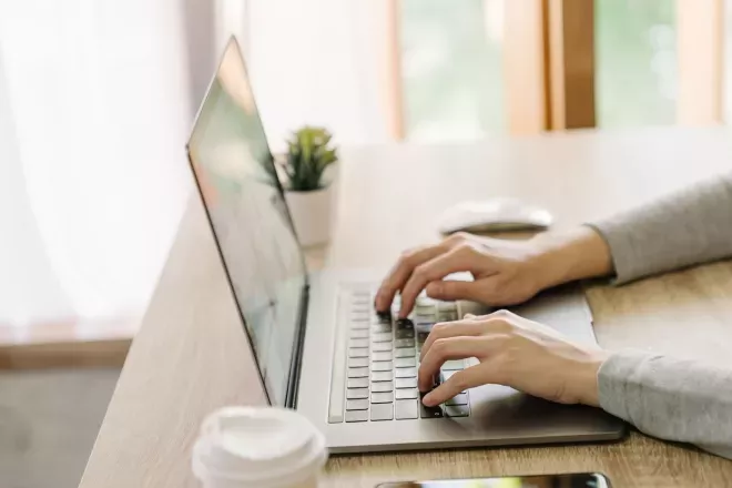 Hände tippen auf Laptop