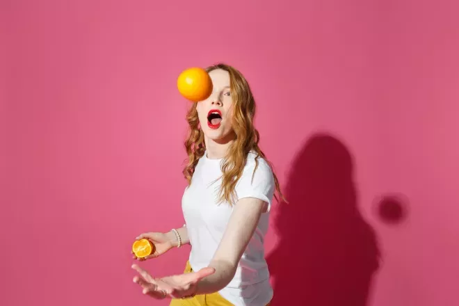 Frau jongliert mit Orangen