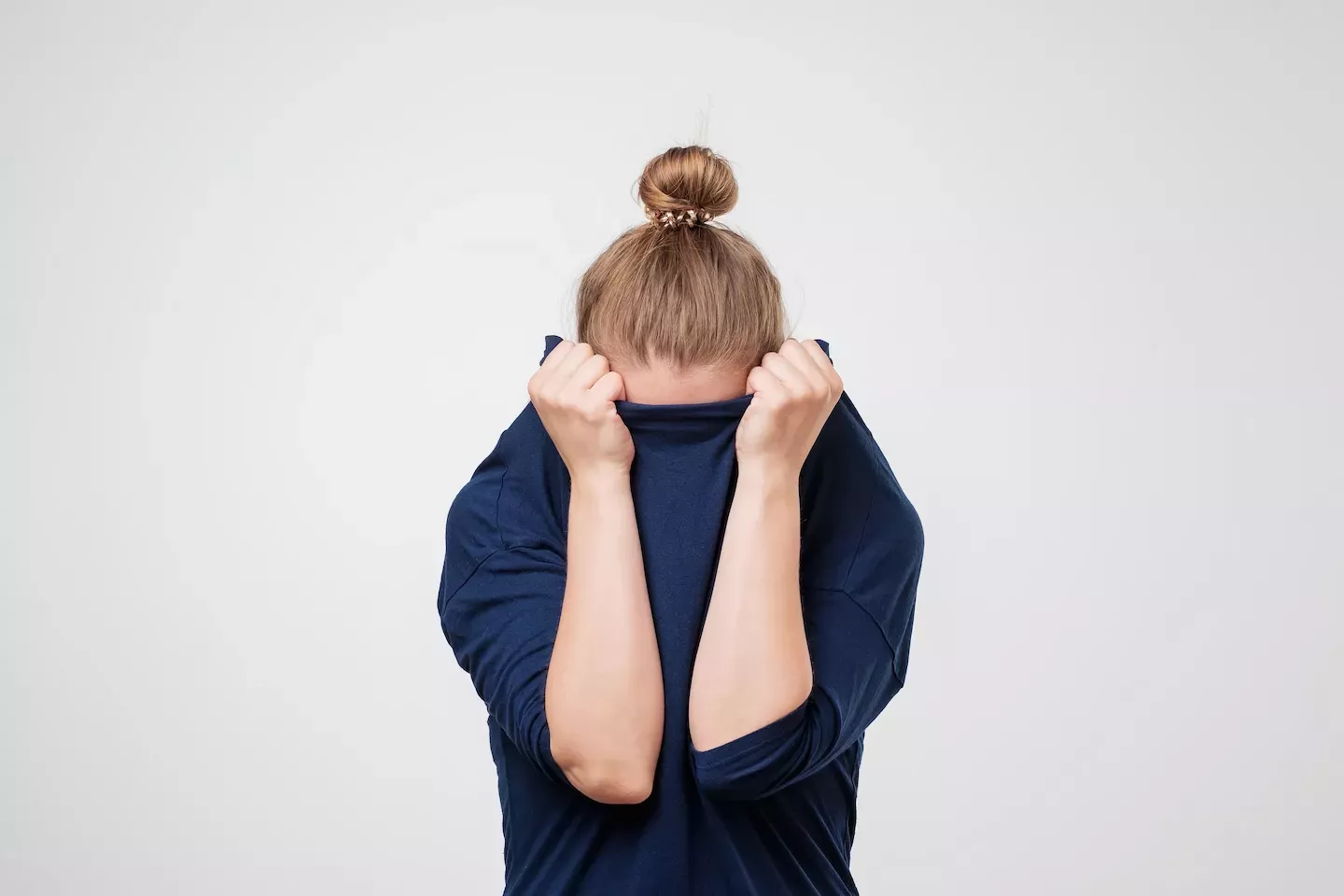 Person, die sich in ihrem Pullover versteckt