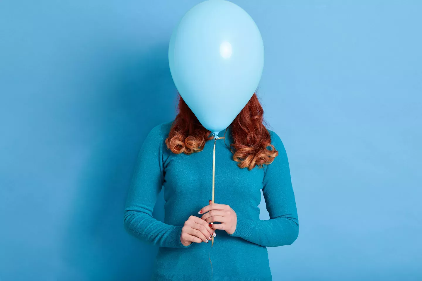 Person, die sich hinter einem Ballon versteckt
