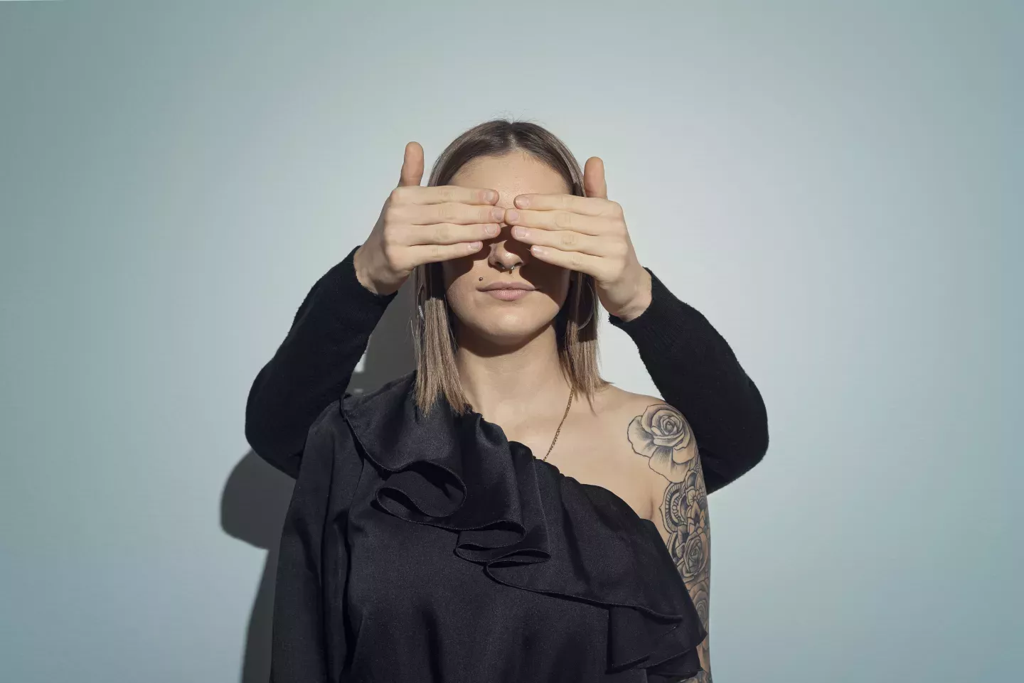 Frau mit Händen, die sich die Augen zuhalten