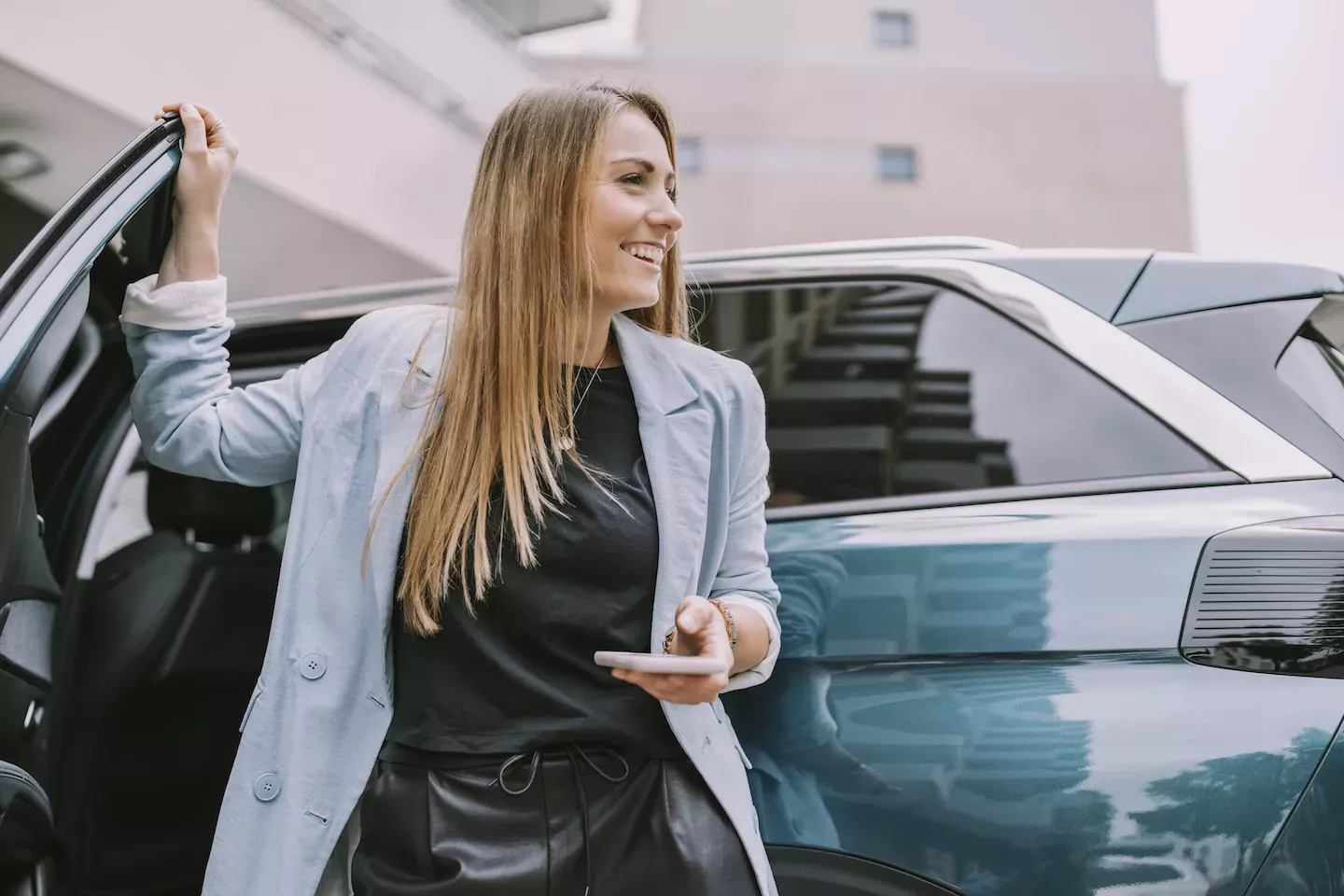 Frau öffnet eine Autotür