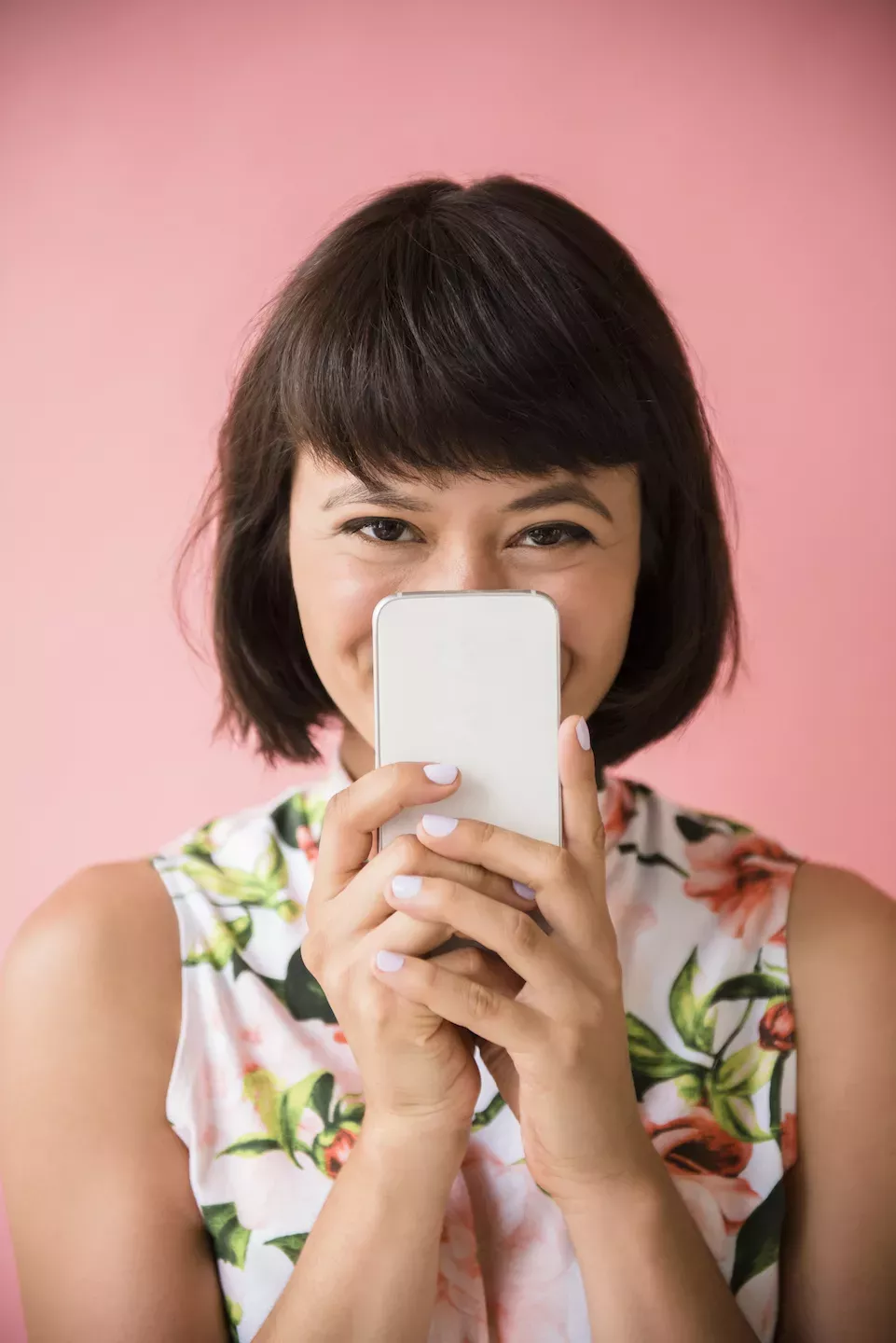 Frau, die sich hinter einem Telefon versteckt
