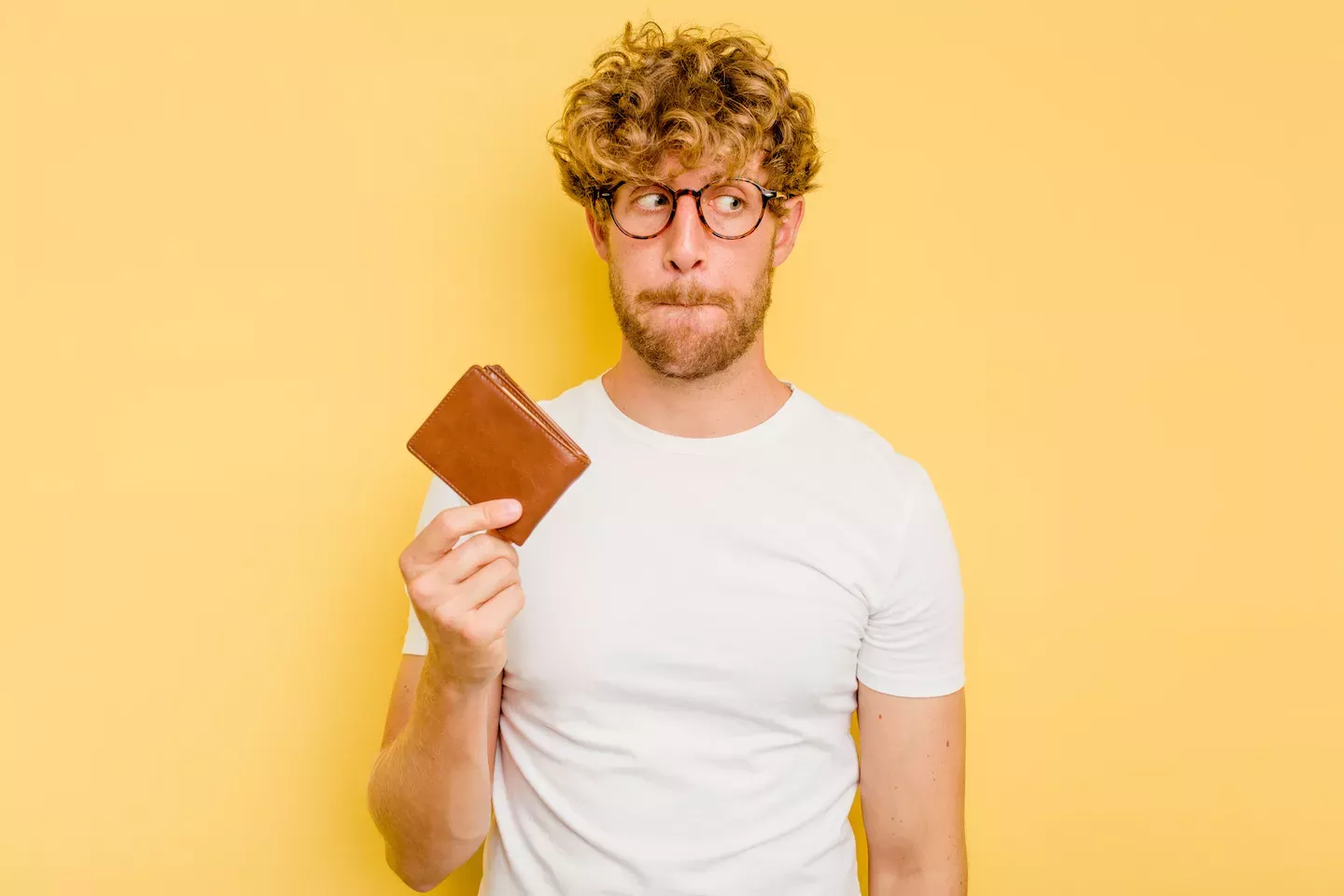 Besorgter Mann hält Brieftasche hoch concerned man holding up wallet