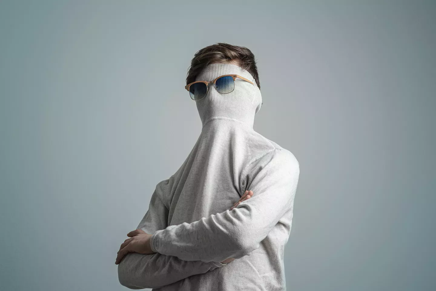 Mann mit Pullover und Sonnenbrille vor dem Gesicht Mann mit Pullover und Sonnenbrille vor dem Gesicht