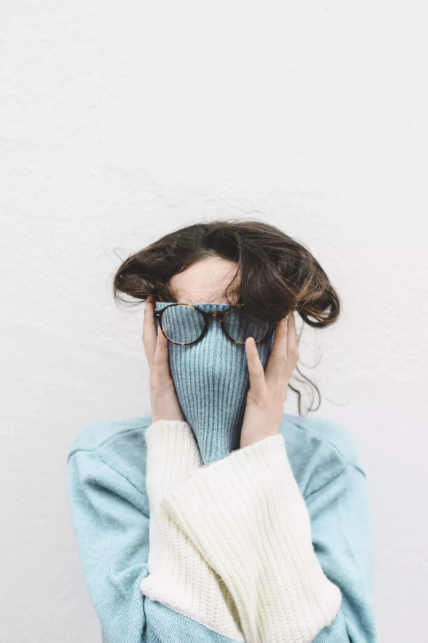 Frau versteckt sich in ihrem Pullover Woman hiding in her sweater