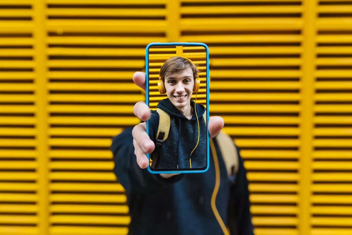 Man holding a phone with his picture on it