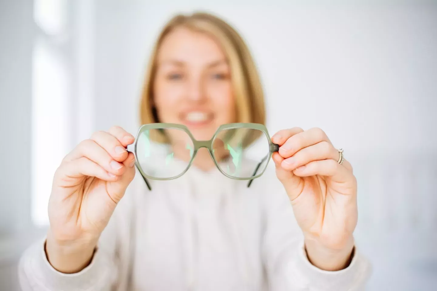 Person, die eine Brille hochhält