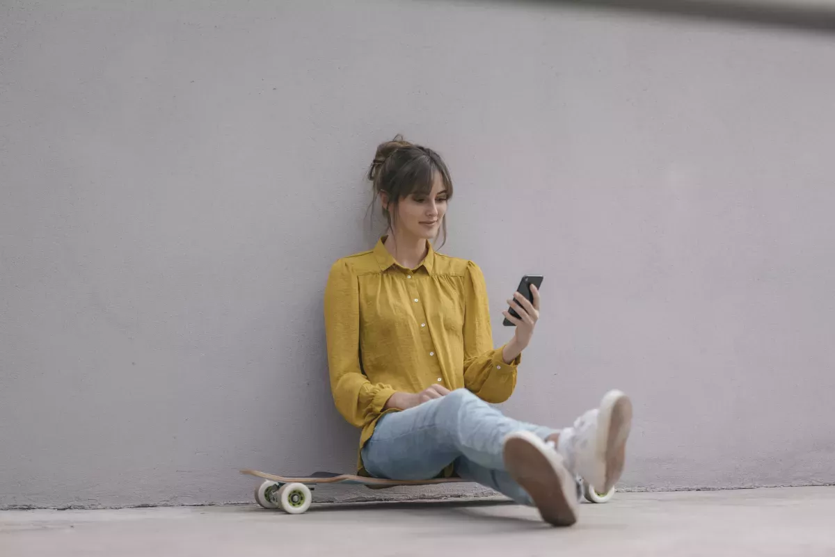 Mujer sentada mientras mira el teléfono