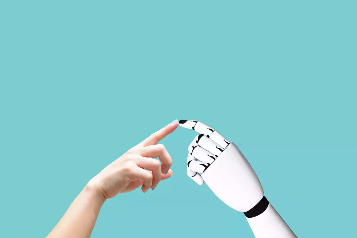 Persona tocando el dedo de un robot