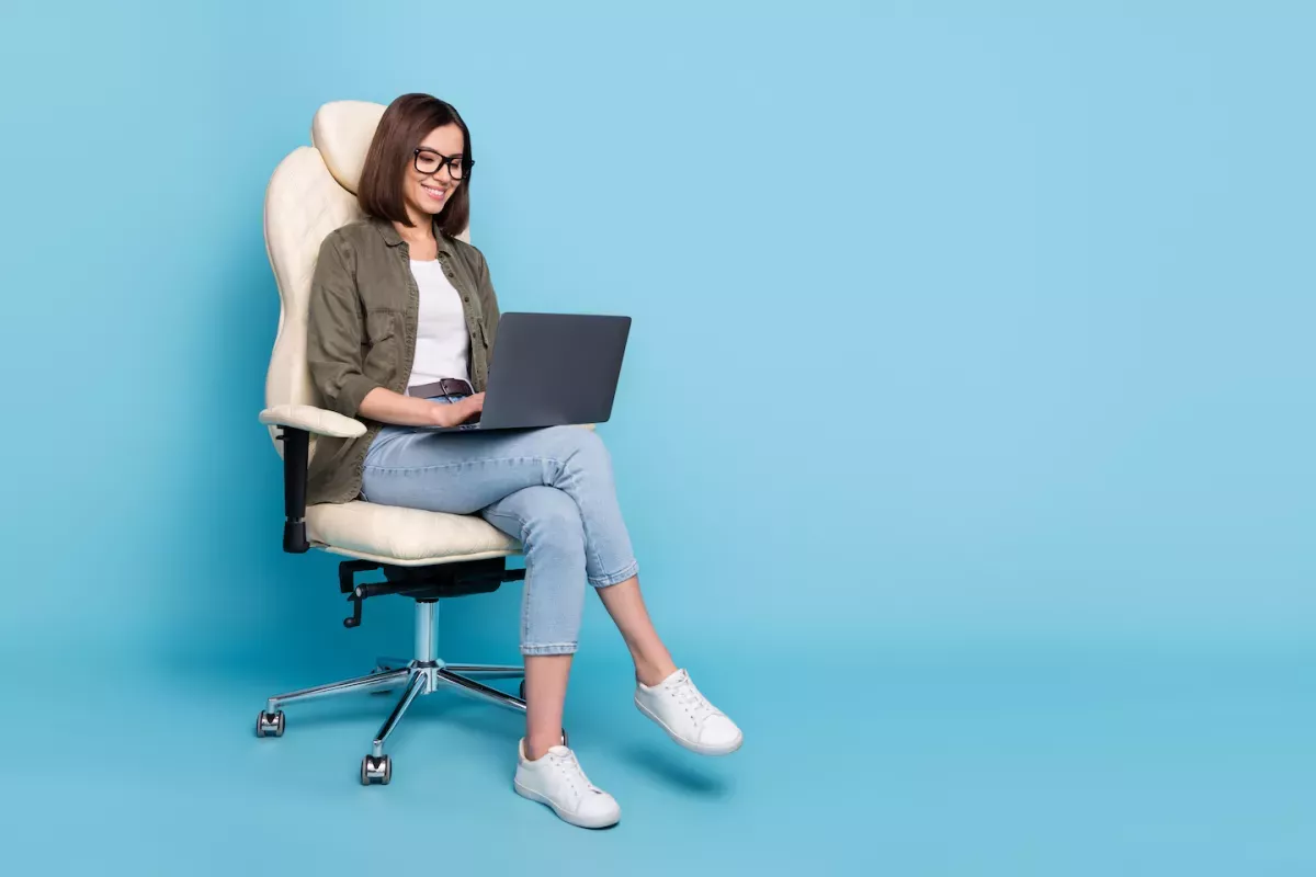 Persona sentada en una silla en una computadora portátil