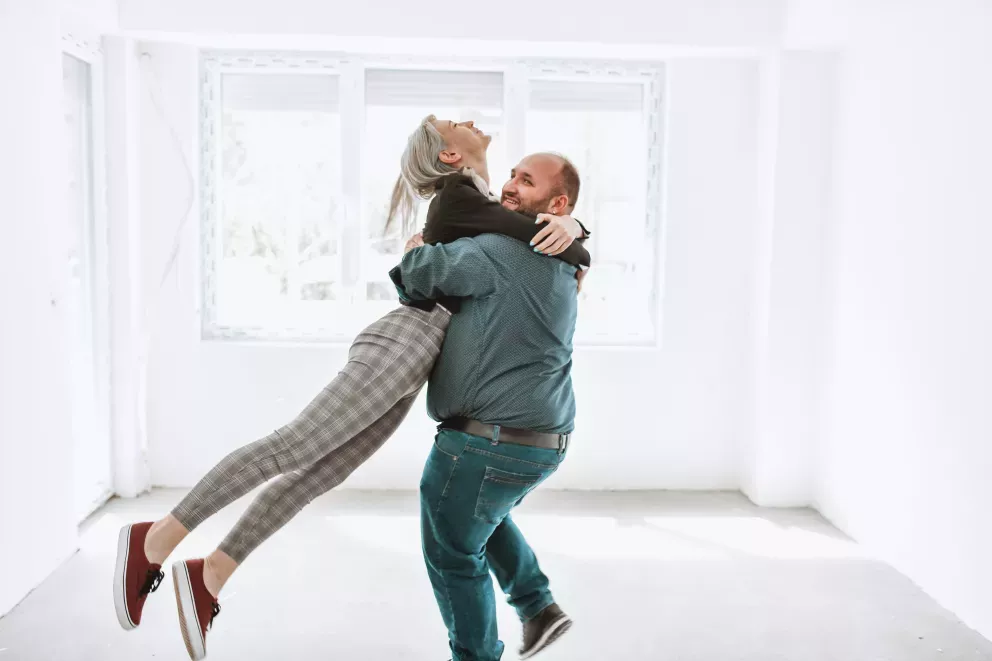 Pareja feliz celebrando bailando en su nuevo hogar