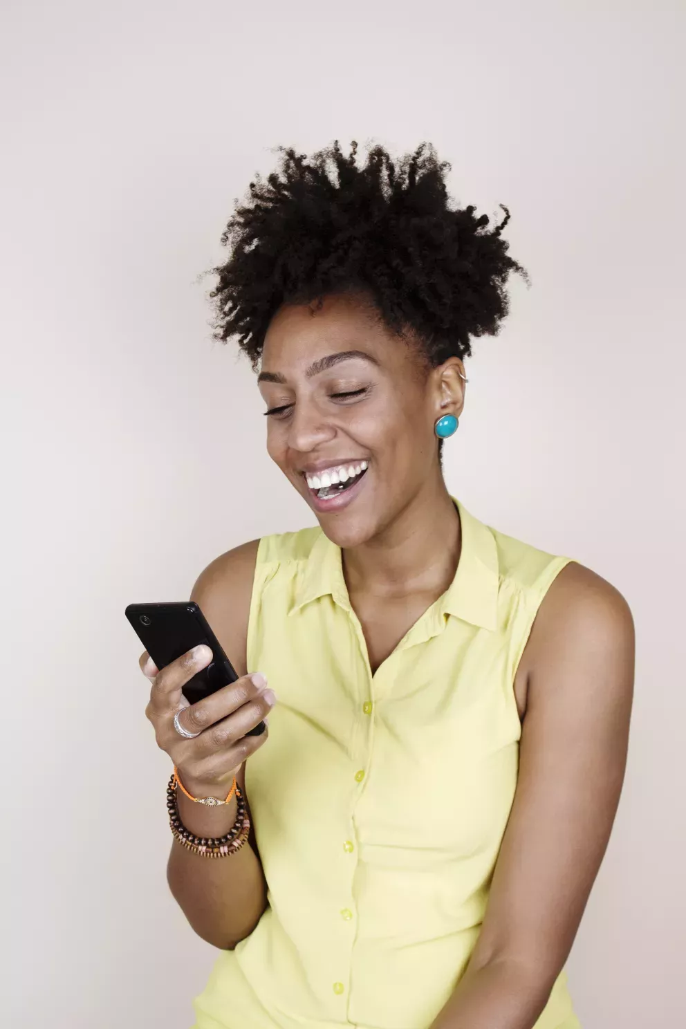 mujer sonriente mirando un teléfono celular