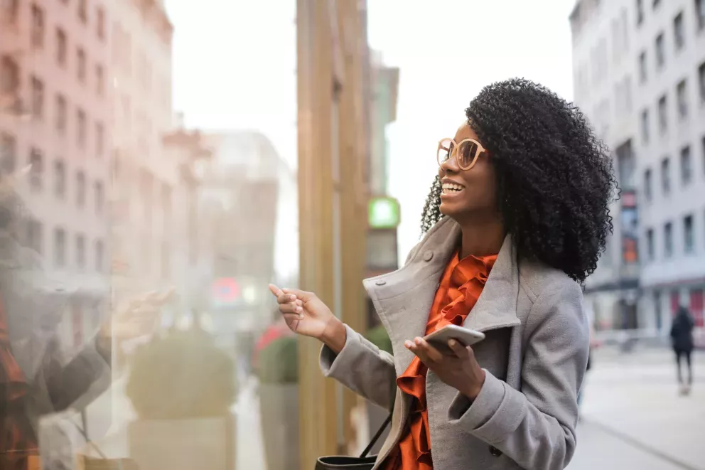 mujer sonriente mirando escaparates en la gran ciudad mujer sonriente mirando escaparates en la gran ciudad