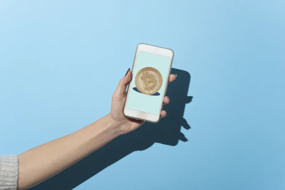 Persona sosteniendo un teléfono con una imagen de bitcoin