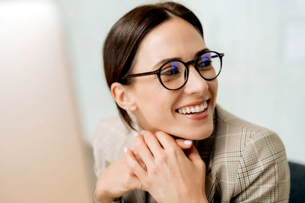 Mujer en una computadora sonriendo