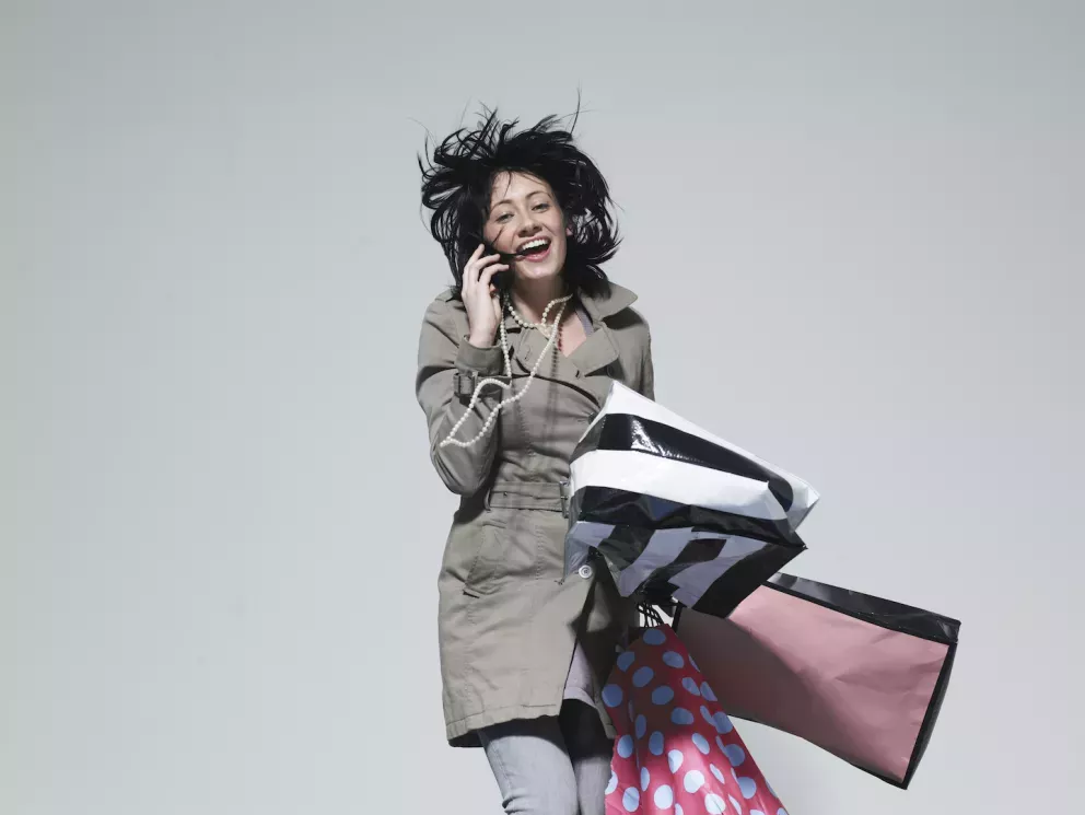 Mujer feliz saltando con bolsas de la compra