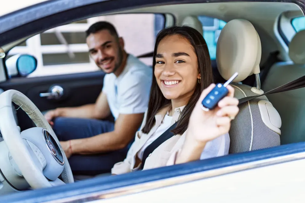 Pareja conduciendo un coche nuevo