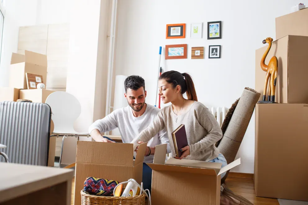 Pareja desempacando cajas en un nuevo hogar
