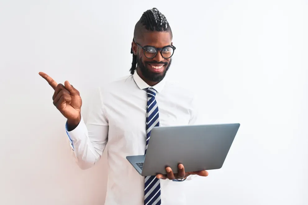 hombre de negocios sonriente sosteniendo una computadora portátil