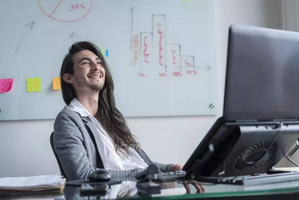 persona de negocios sonriente sentada en el escritorio persona de negocios sonriente sentada en el escritorio