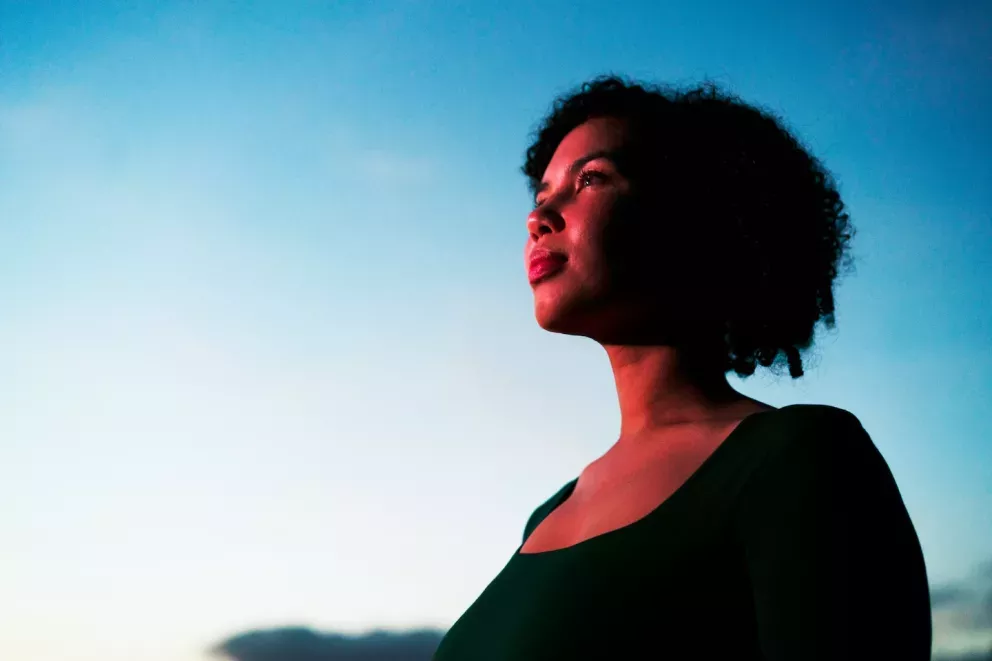 woman looking hopeful towards the sunrise