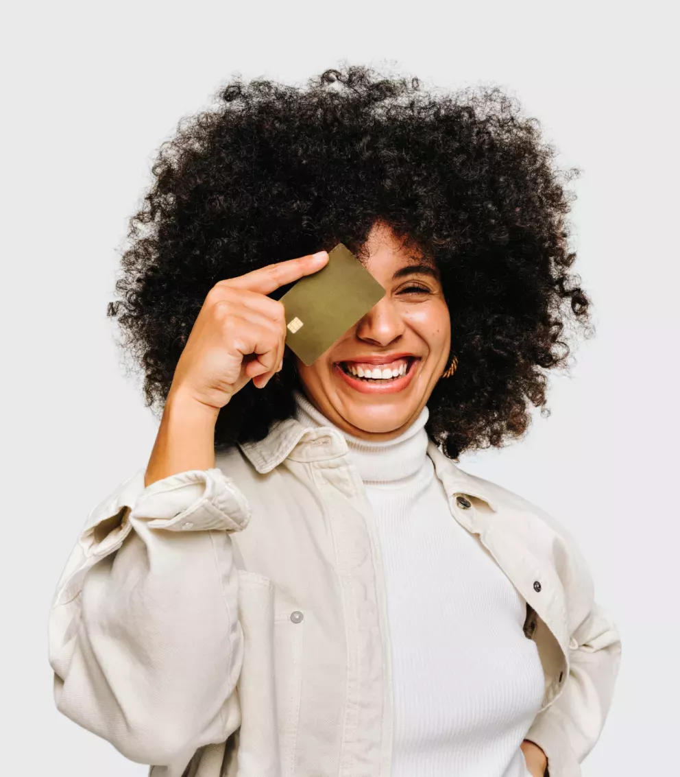 Mujer sosteniendo una tarjeta de crédito sobre el ojo