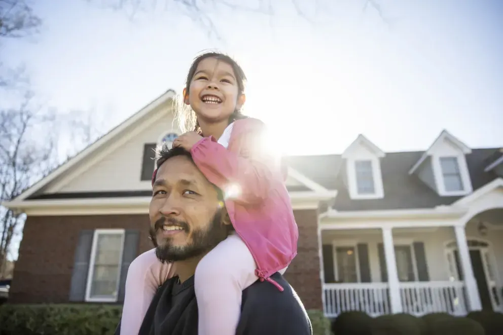 Padre feliz con un niño sonriente sobre sus hombros.