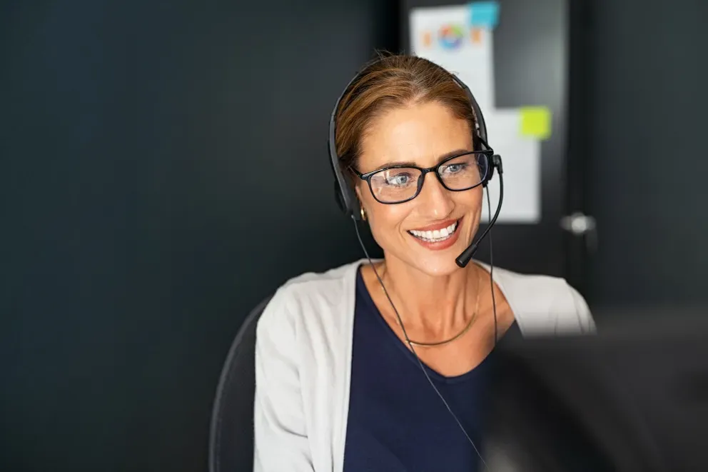 Woman in call center with headset and computer Woman in call center with headset and computer