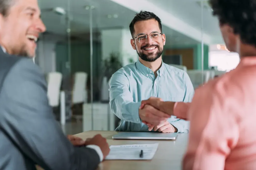 hombre de negocios sonriente estrechando la mano de los clientes