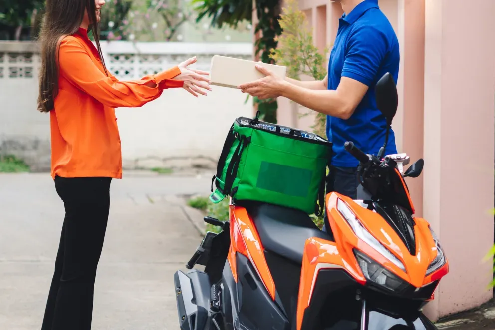 Repartidor con moto y paquete