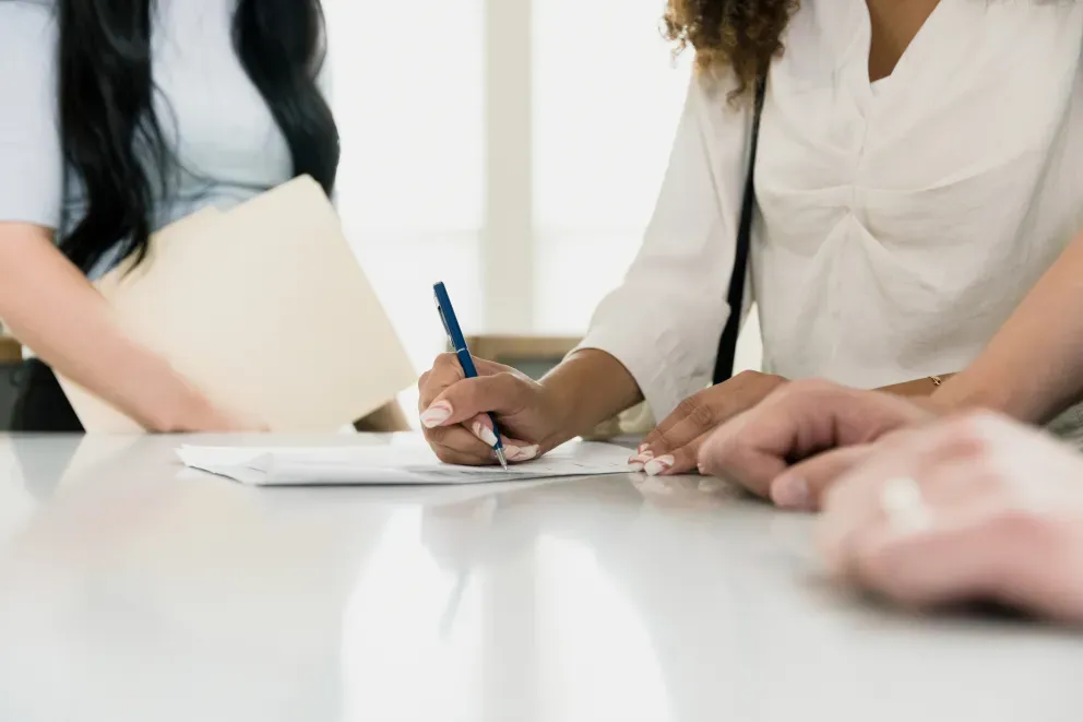 Mujeres en reunión con lápiz y papel
