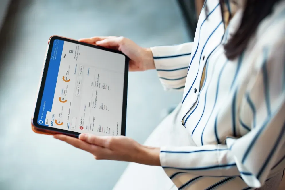 Mujer con camisa a rayas sosteniendo una tableta que muestra un tablero de datos con gráficos. Mujer con camisa a rayas sosteniendo una tableta que muestra un tablero de datos con gráficos.