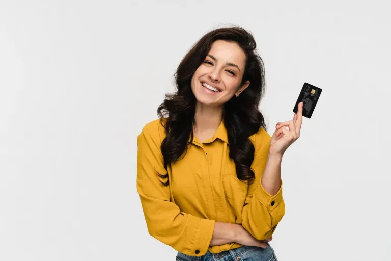 Woman holding a credit card and smiling Woman holding a credit card and smiling