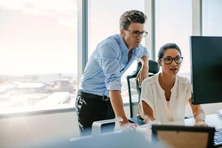 Woman and man looking at a monitor at work.