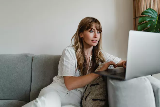 Mujer en el sofá usando una computadora portátil Mujer en el sofá usando una computadora portátil