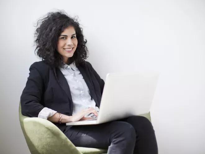 Mujer en silla usando una computadora portátil Mujer en silla usando una computadora portátil