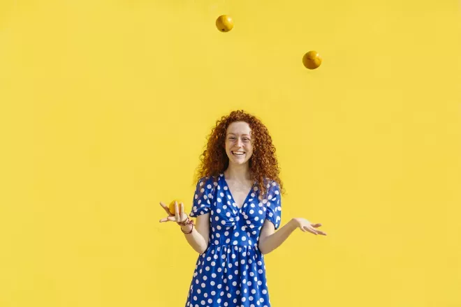 Mujer haciendo malabares con naranjas