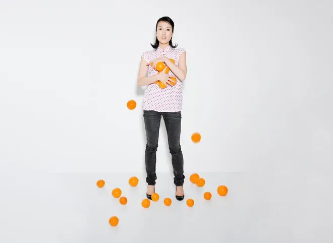 Mujer luchando por sostener naranjas