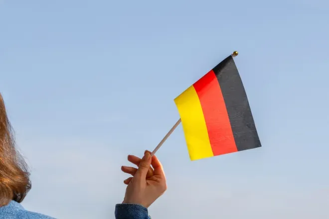 Woman holding German flag in sky