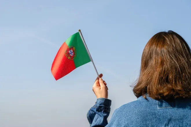 Woman holding Portuguese flag in sky