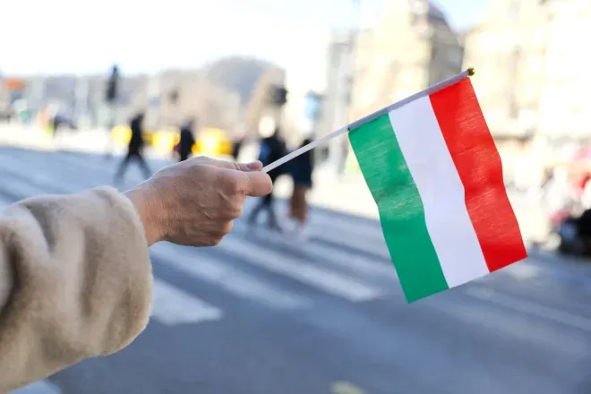 Hand holding Hungarian flag in street