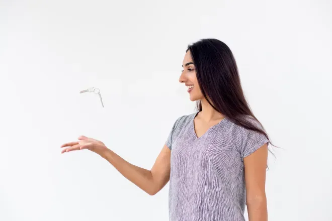 Joven sonriente con cabello oscuro que extiende la mano, lanzando vasos al aire. Joven sonriente con cabello oscuro que extiende la mano, lanzando vasos al aire.