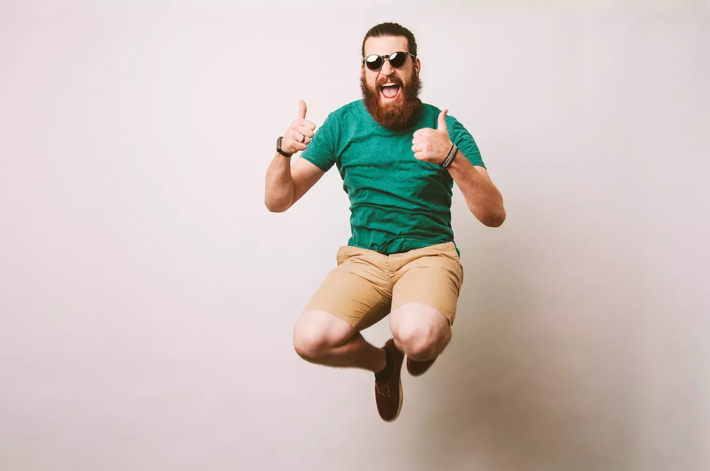 Hombre saltando en el aire levantando el pulgar
