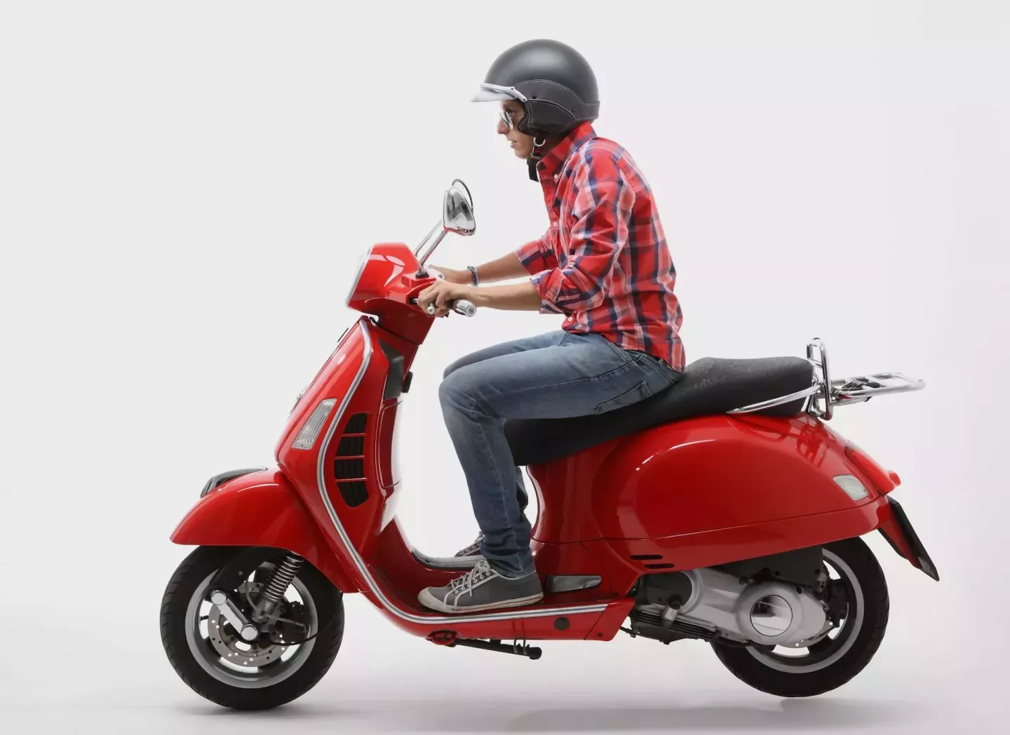 Hombre montando un scooter rojo