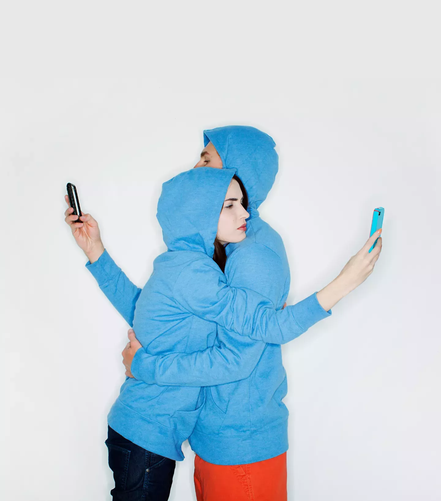 Dos personas abrazándose y mirando teléfonos Dos personas abrazándose y mirando teléfonos