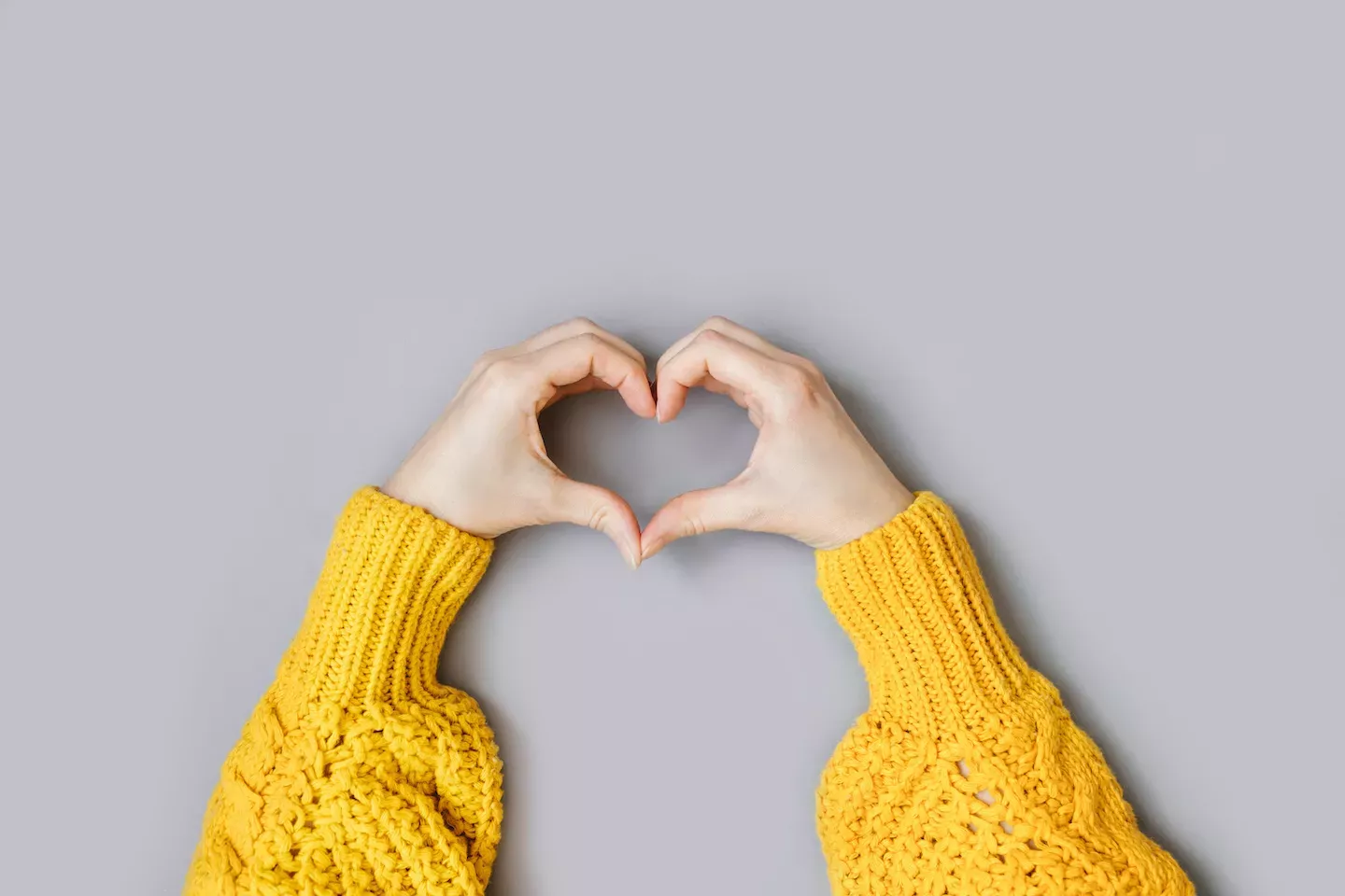 Persona haciendo la forma de un corazón con sus manos