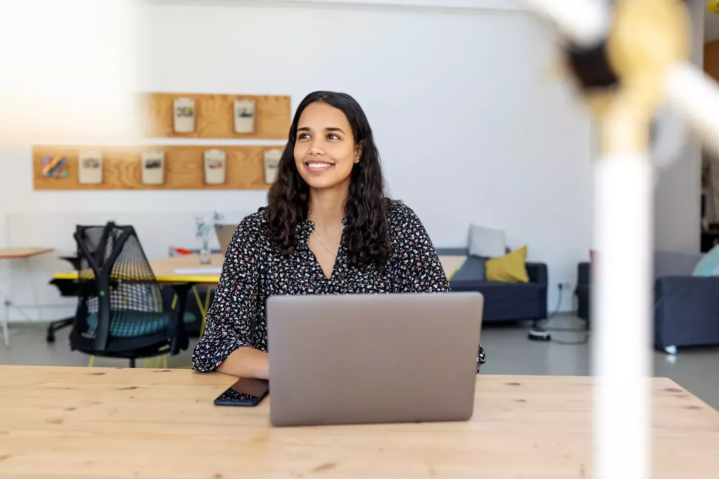 Mujer sonriendo y sosteniendo una computadora portátil
