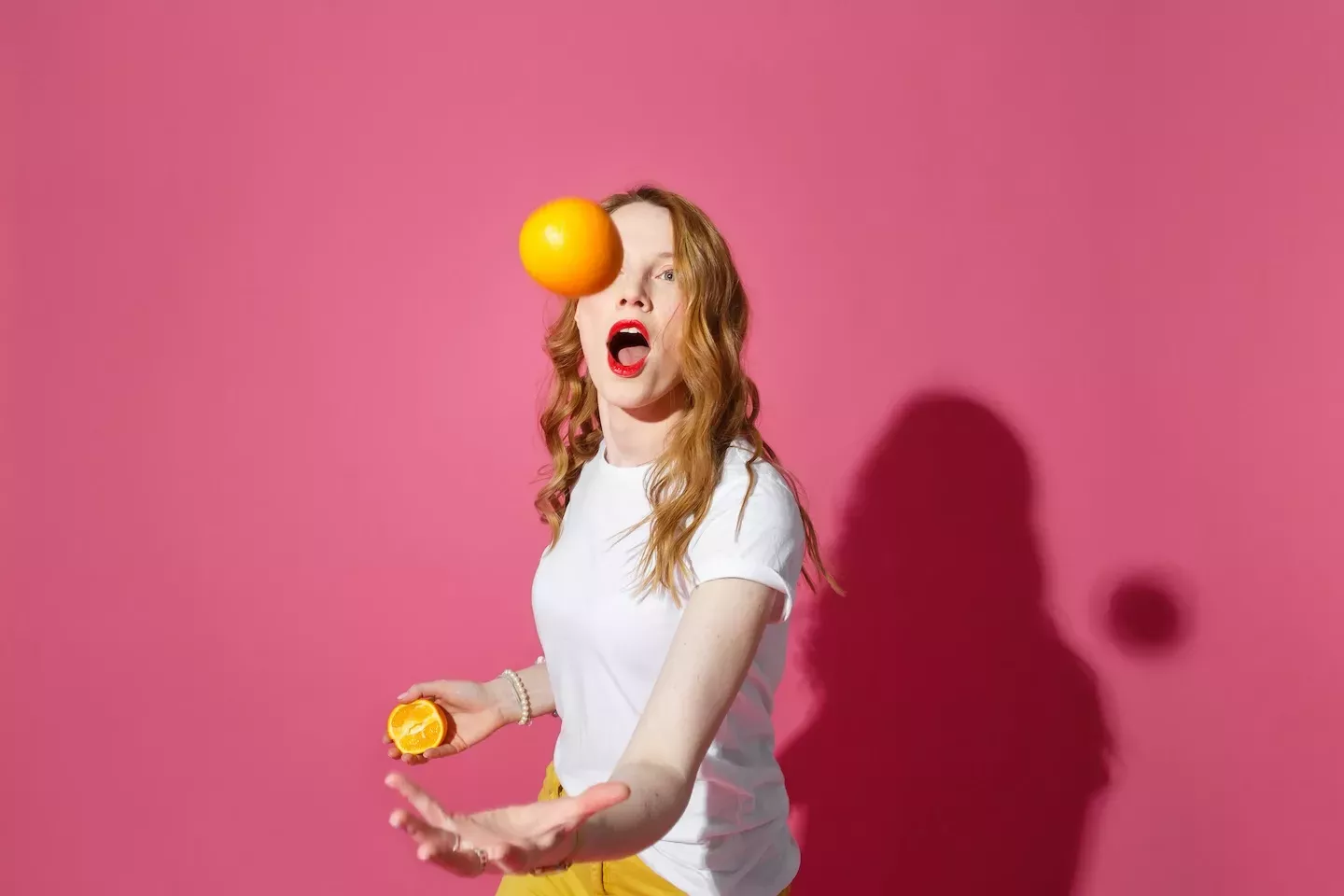Mujer haciendo malabares con naranjas