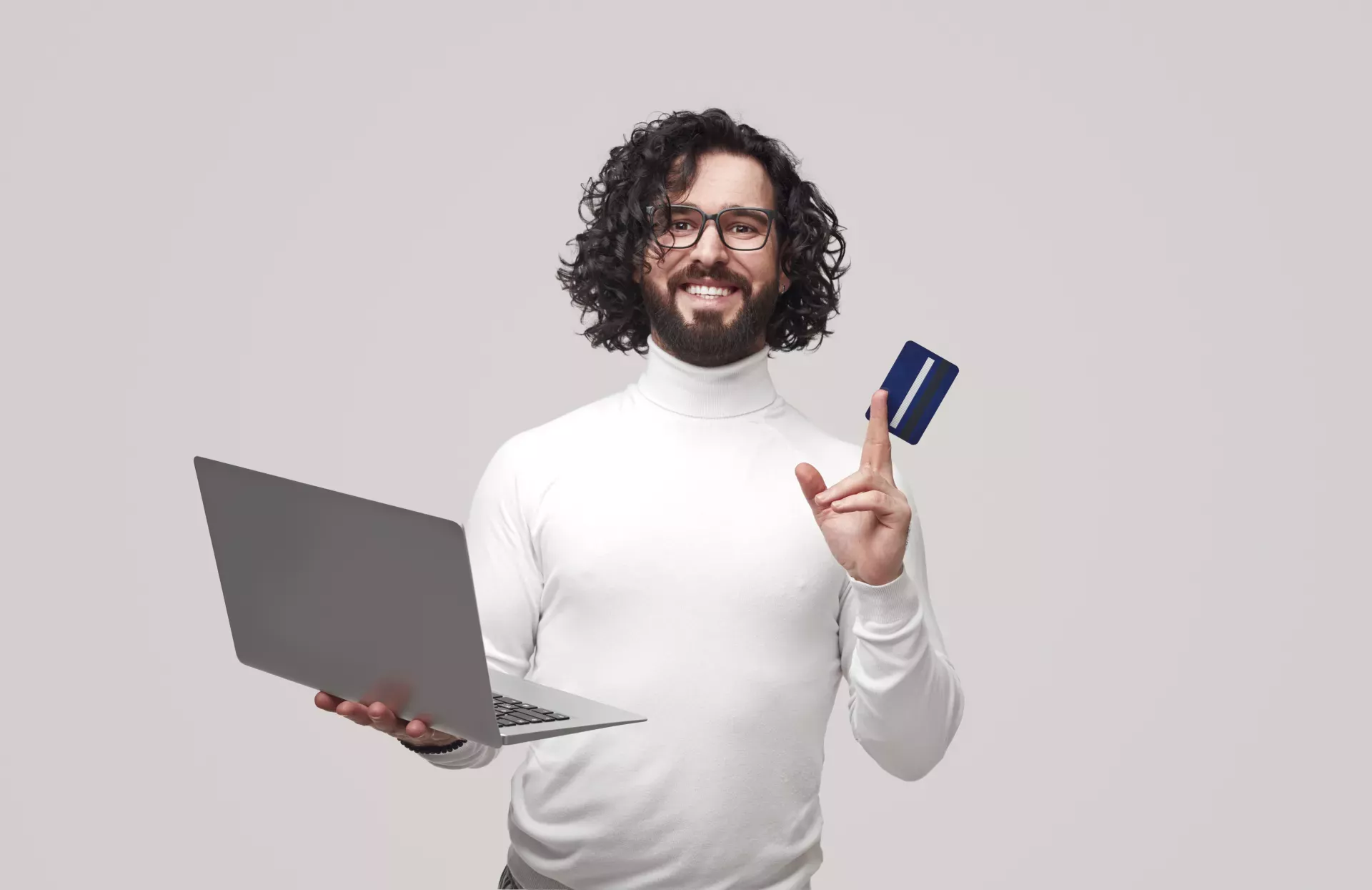 Hombre sosteniendo una computadora portátil y una tarjeta de débito Hombre sosteniendo una computadora portátil y una tarjeta de débito